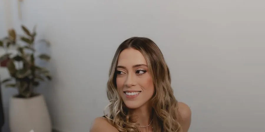 Nathalia Lourenço sorrindo, ao lado de uma planta